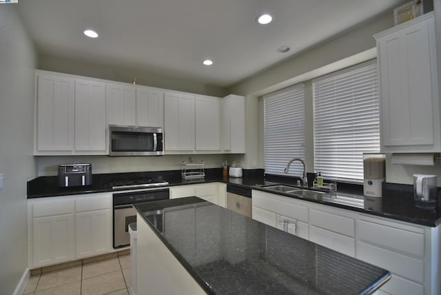 kitchen with white cabinetry, sink, light tile patterned floors, and appliances with stainless steel finishes