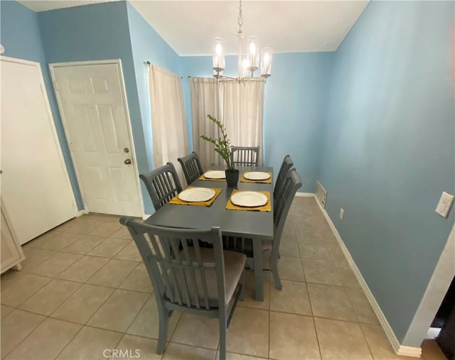 tiled dining area featuring an inviting chandelier