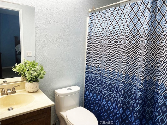 bathroom with a shower with curtain, vanity, and toilet