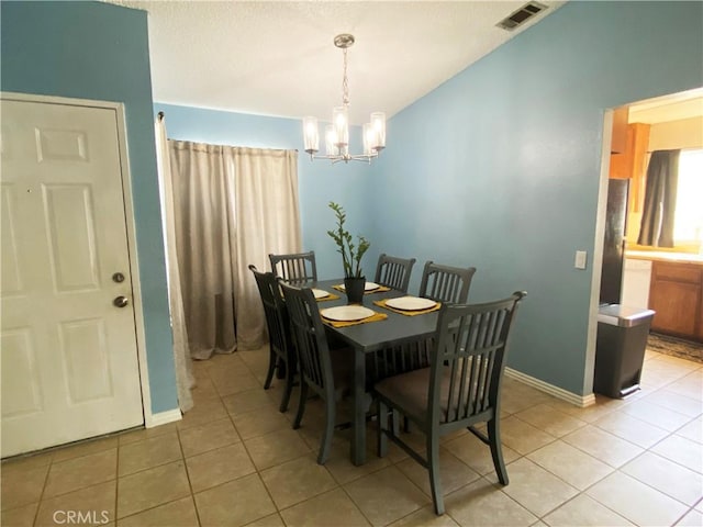 dining area featuring light tile patterned flooring and a chandelier