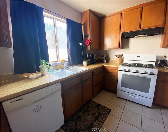 kitchen featuring light tile patterned floors, white appliances, and sink