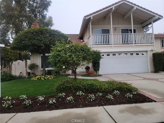 view of front facade with a front lawn, a balcony, and a garage