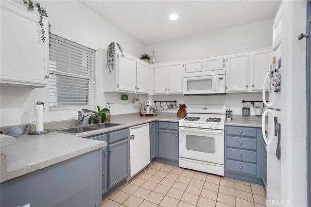 kitchen with white cabinetry, white appliances, sink, and light tile patterned floors