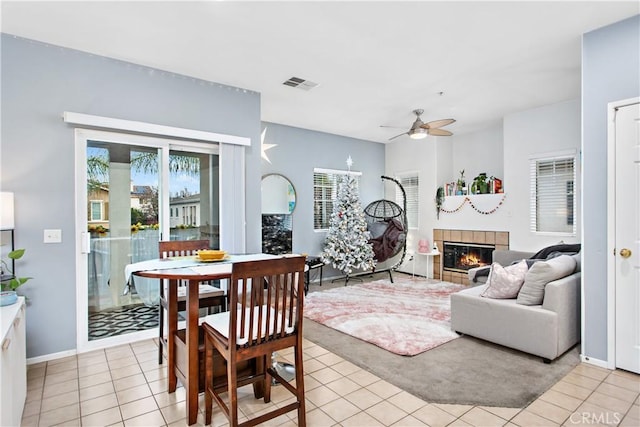 living room with ceiling fan, a fireplace, and light tile patterned floors