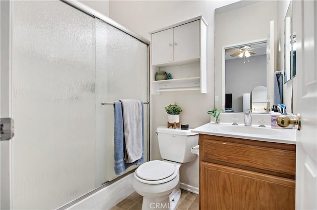 bathroom with vanity, a shower with door, ceiling fan, tile patterned flooring, and toilet