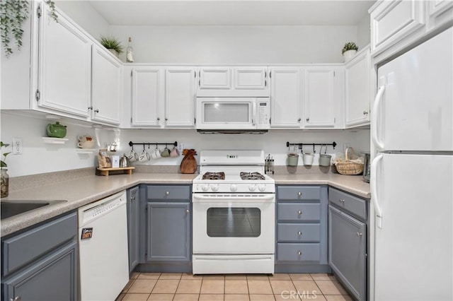 kitchen featuring white cabinets, gray cabinets, white appliances, and light tile patterned floors