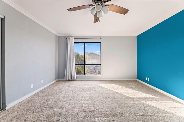 carpeted spare room featuring ceiling fan and crown molding