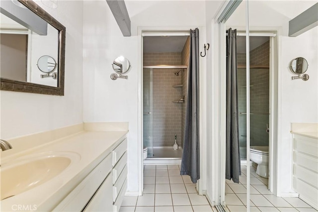 bathroom featuring tile patterned flooring, vanity, toilet, and an enclosed shower