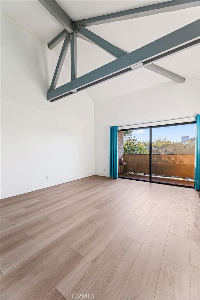 spare room featuring light hardwood / wood-style flooring, beamed ceiling, and high vaulted ceiling