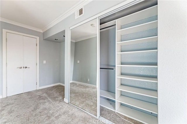 interior space featuring a closet, carpet, and ornamental molding