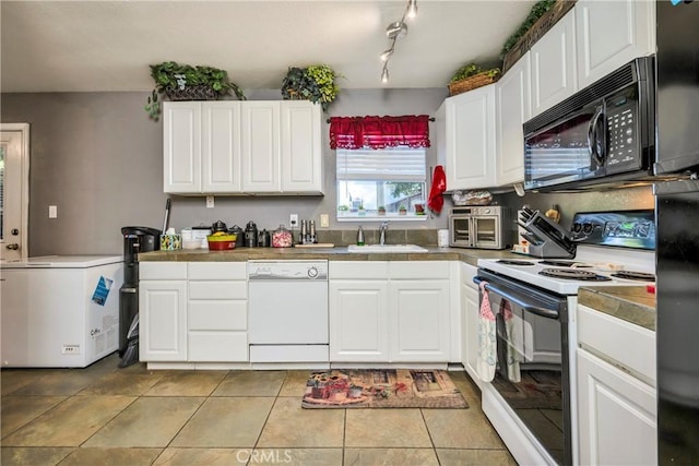 kitchen featuring white cabinets, light tile patterned floors, white appliances, and sink