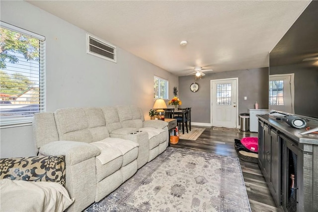 living room featuring dark hardwood / wood-style floors and ceiling fan