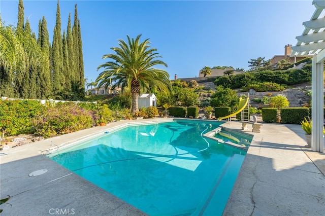 view of swimming pool featuring an in ground hot tub and a water slide