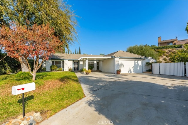 ranch-style home featuring a front lawn and a garage