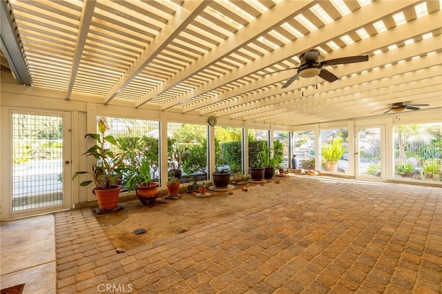 unfurnished sunroom with ceiling fan