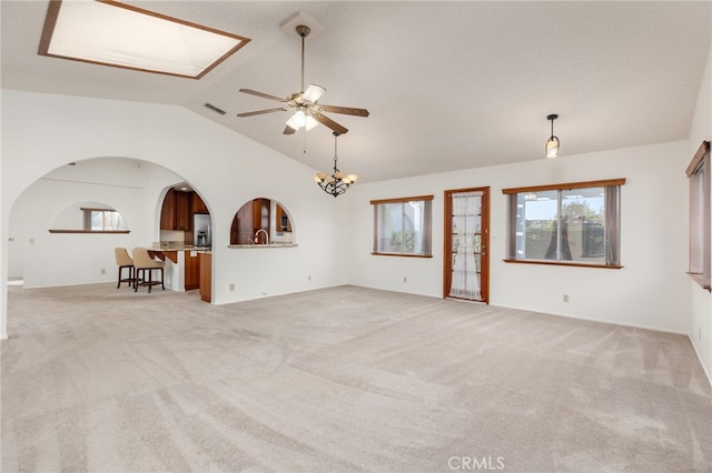 unfurnished living room featuring light carpet, vaulted ceiling, and ceiling fan