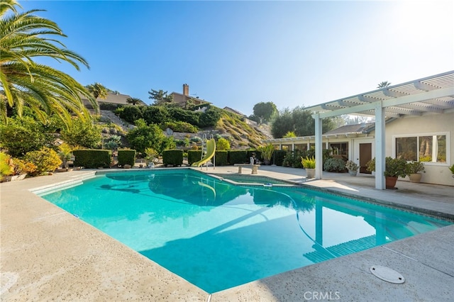 view of pool featuring a pergola, a patio area, and a water slide