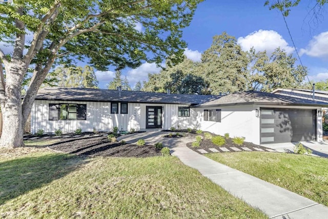 ranch-style house featuring a front lawn and a garage