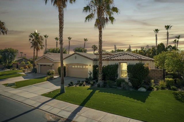 view of front of home with a garage and a yard