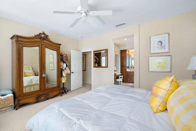 carpeted bedroom featuring ceiling fan and ensuite bath