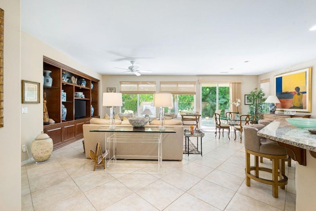 living room featuring light tile patterned floors, a wealth of natural light, and ceiling fan