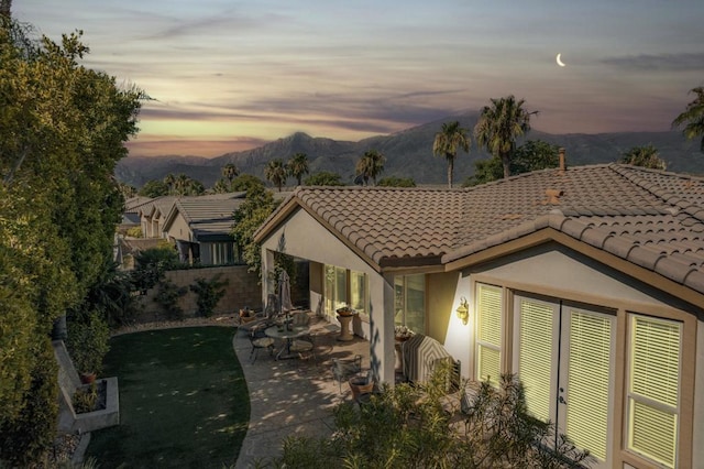 exterior space with a patio, a mountain view, and a yard