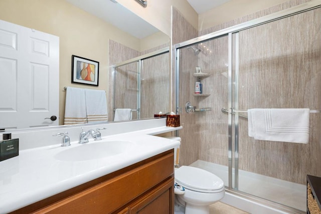 bathroom featuring vanity, toilet, and a shower with shower door