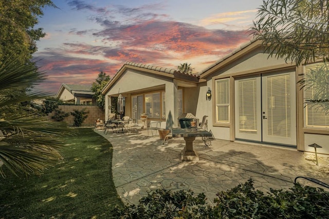 back house at dusk featuring a patio