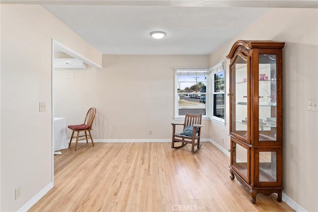 living area featuring light wood-type flooring and a wall mounted AC