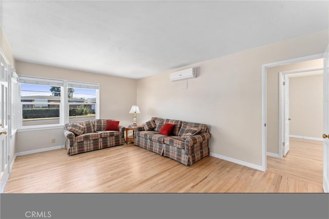 living room featuring a wall mounted AC and light hardwood / wood-style floors