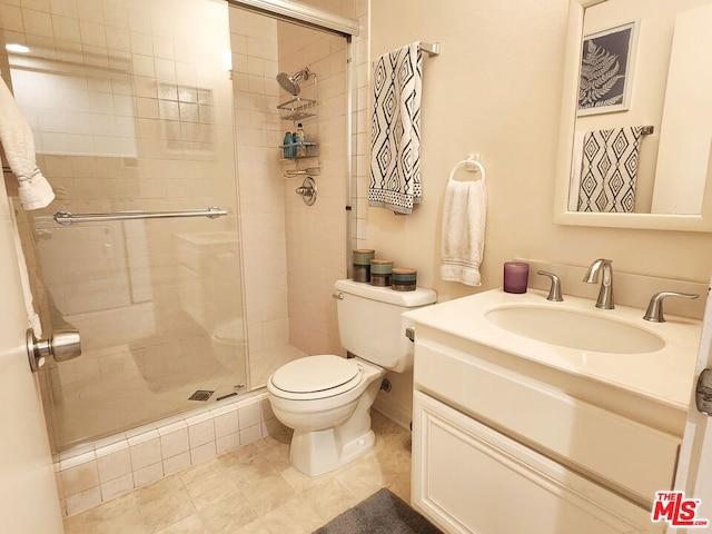 bathroom featuring vanity, a shower with shower door, and toilet