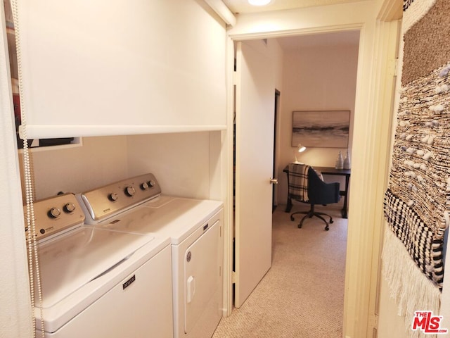 clothes washing area featuring light colored carpet and separate washer and dryer