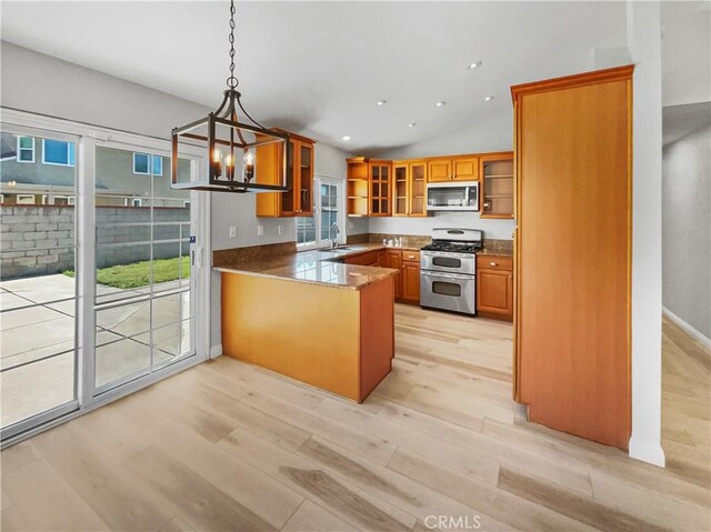 kitchen featuring kitchen peninsula, stainless steel appliances, light hardwood / wood-style flooring, decorative light fixtures, and vaulted ceiling