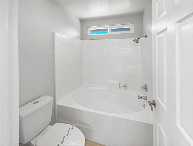 bathroom featuring shower / tub combination, a textured ceiling, and toilet