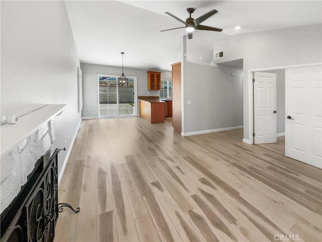 unfurnished living room with ceiling fan, lofted ceiling, and light hardwood / wood-style floors