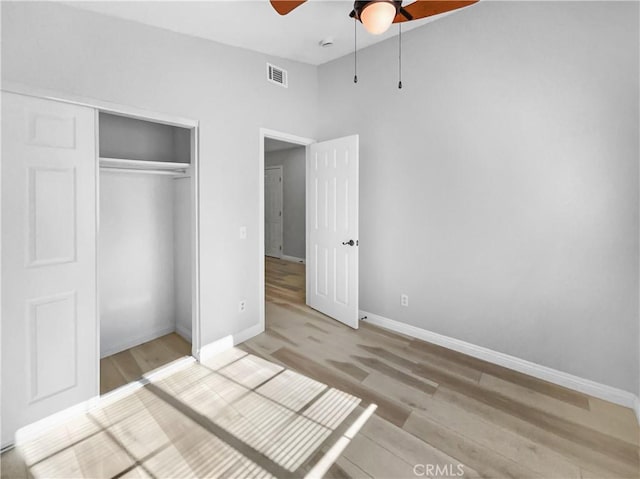 unfurnished bedroom featuring a closet, vaulted ceiling, ceiling fan, and light hardwood / wood-style flooring