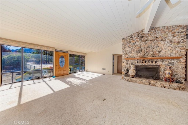 unfurnished living room featuring vaulted ceiling with beams, a fireplace, and carpet flooring