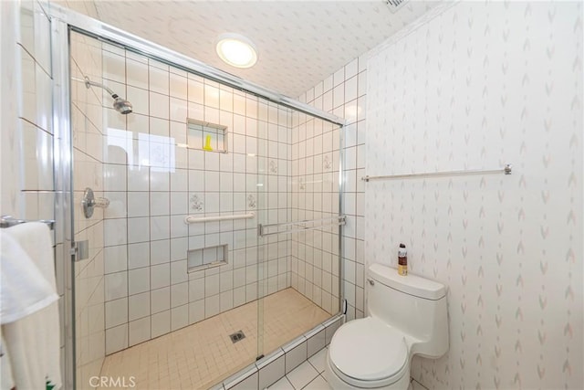 bathroom with a stall shower and toilet