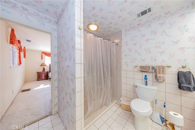 bathroom with visible vents, tile walls, toilet, and wallpapered walls