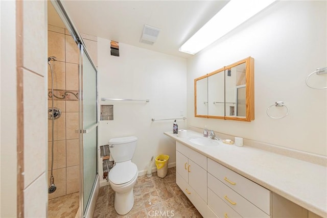 bathroom with a stall shower, baseboards, visible vents, toilet, and vanity