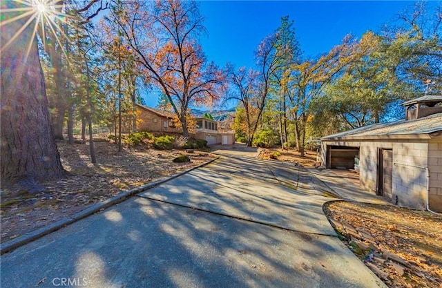 exterior space featuring a garage, concrete driveway, and concrete block siding