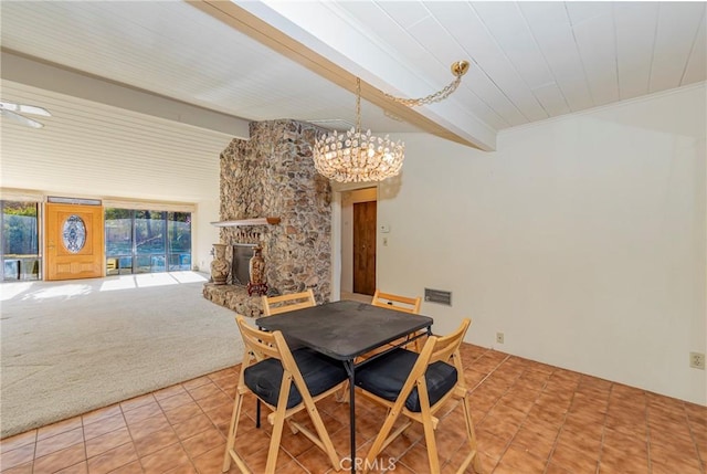 dining room with beam ceiling, light colored carpet, a fireplace, and light tile patterned floors