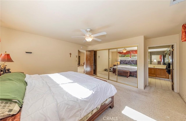 bedroom featuring ceiling fan, connected bathroom, and light colored carpet