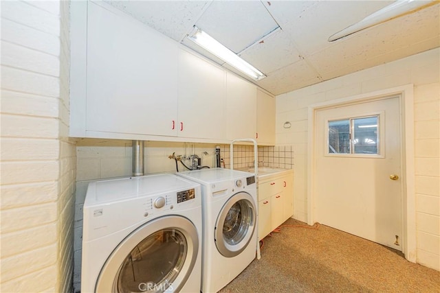 clothes washing area featuring cabinet space, independent washer and dryer, and light carpet