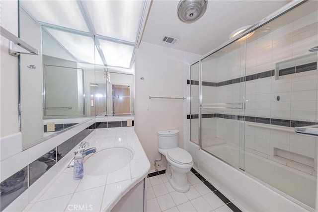 bathroom with visible vents, toilet, shower / bath combination with glass door, tile patterned floors, and vanity