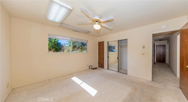 unfurnished bedroom featuring a closet, carpet flooring, and ceiling fan