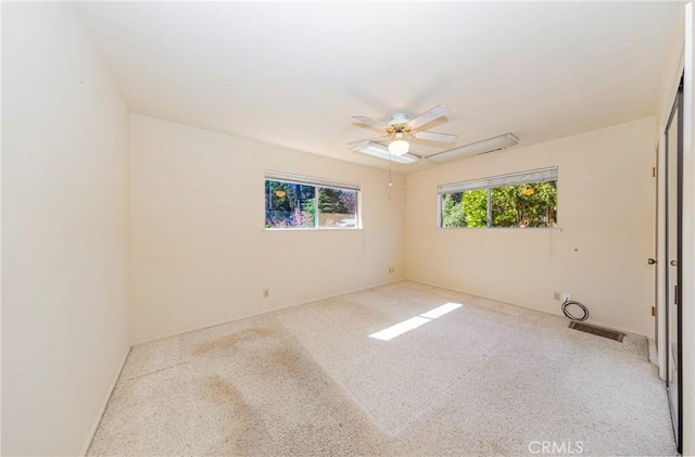 empty room with ceiling fan, speckled floor, and visible vents