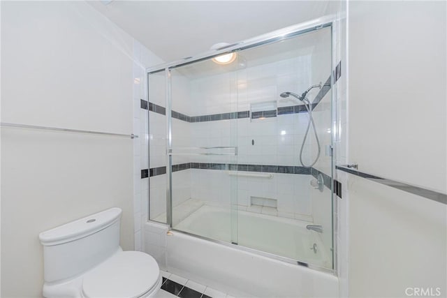 bathroom with enclosed tub / shower combo and toilet