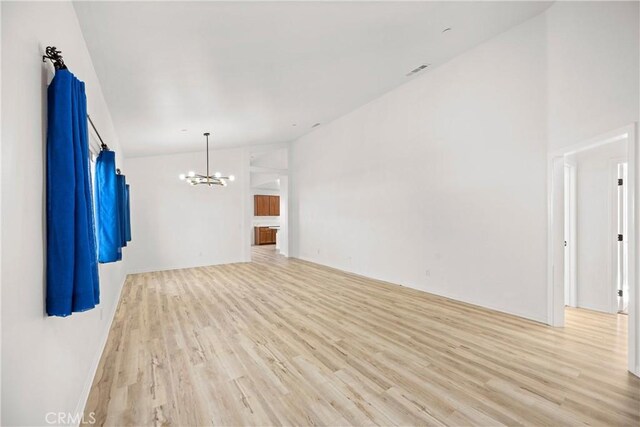 spare room with a chandelier and light hardwood / wood-style floors