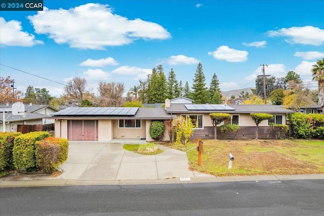 single story home featuring a front yard and solar panels